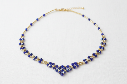 Blått kristallhalsband med vit bakgrund