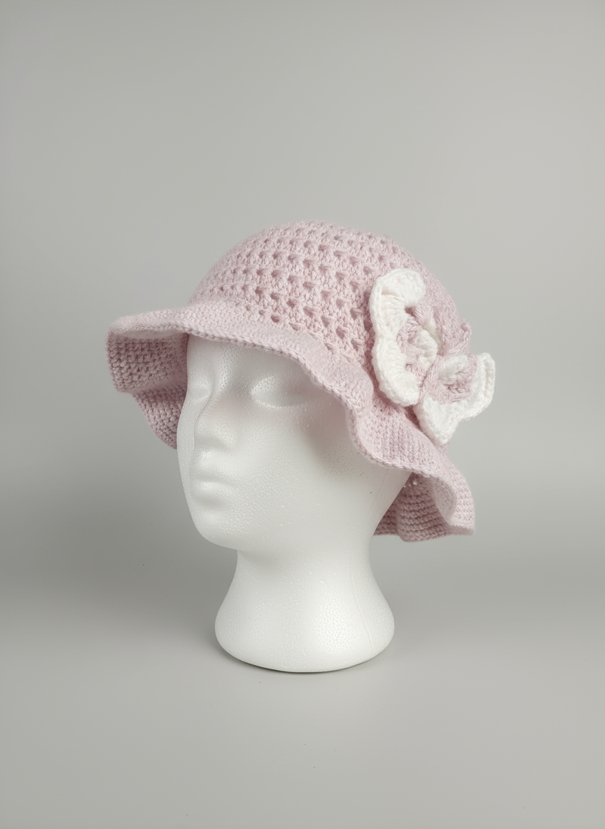 Virkad babyhatt med blomma på mannequin